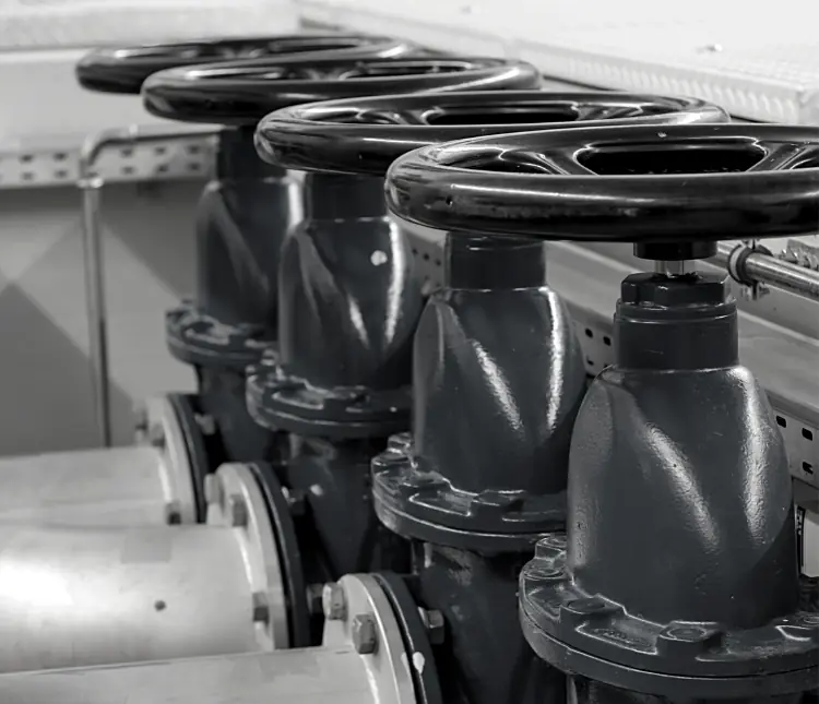 A black-and-white depiction showcases a row of industrial valve handles in a mechanical setting, reflecting the precision integral to CPQ for valve manufacturers.