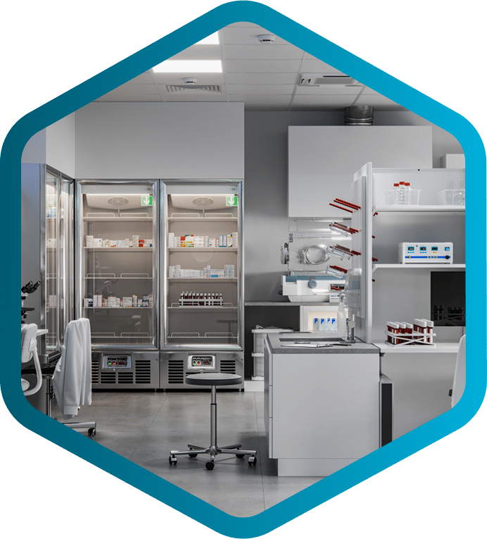 Modern laboratory with white cabinets, refrigerators storing healthcare supply chain essentials, lab equipment on counters, and a stool in the center, all viewed through a hexagonal blue frame.