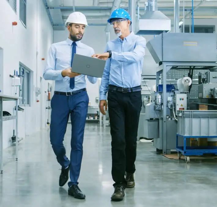 Walking through a manufacturing facility with a laptop