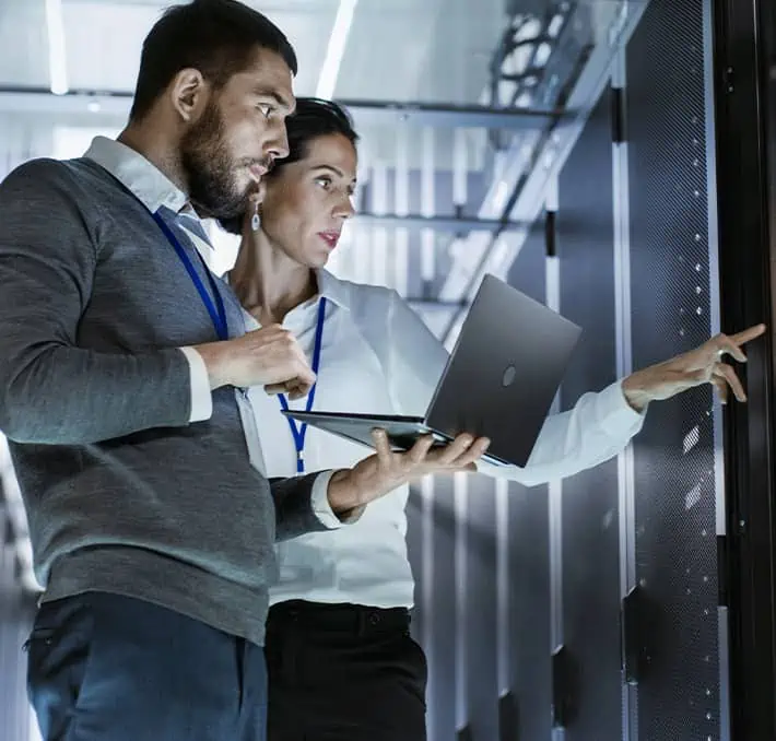 People looking at mainframe with laptop