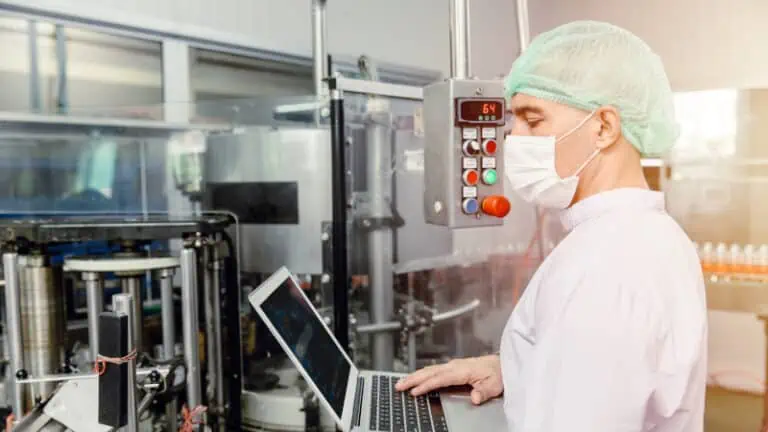 man looking at laptop in clean room