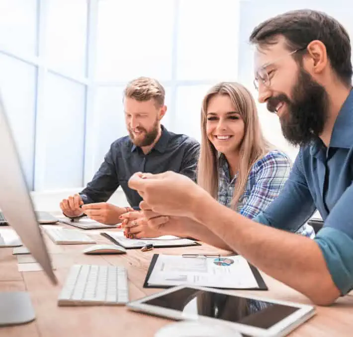 Three people looking at a laptop