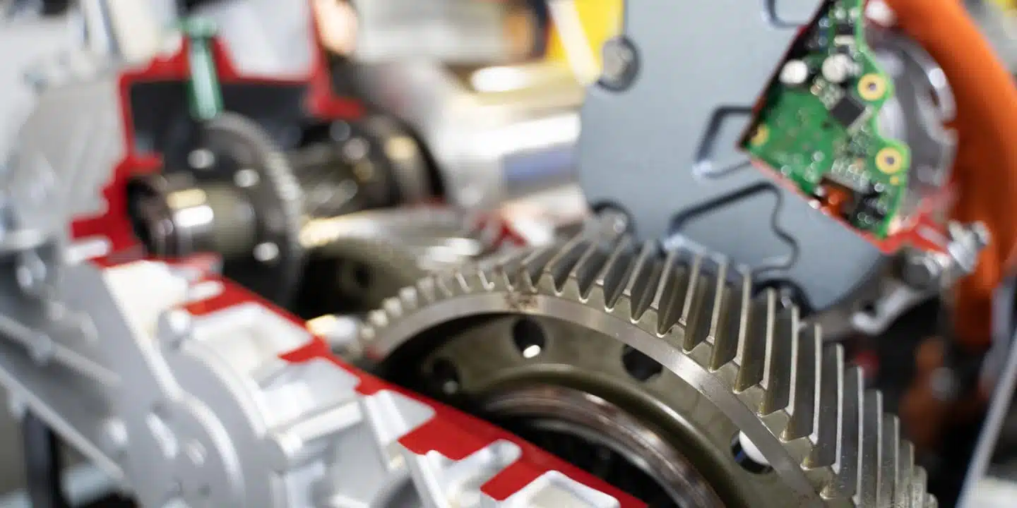 Close-up of mechanical gears and electronic components inside a machine, showcasing the intricate engineering details characteristic of electrical equipment manufacturing.
