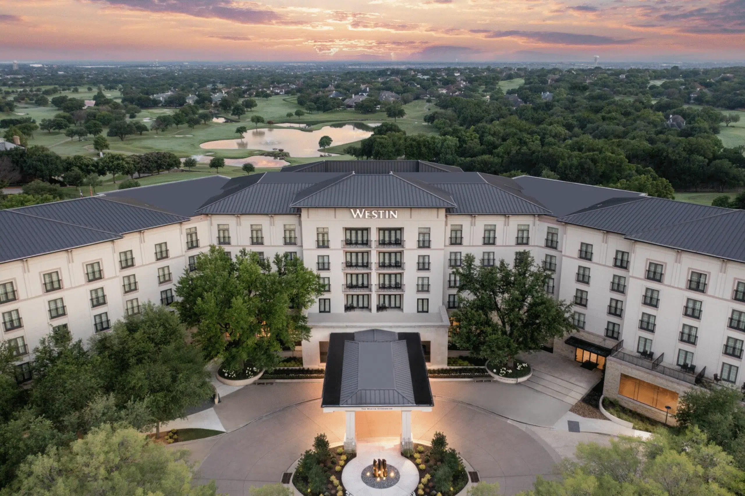 Aerial view of the Westin hotel at sunset, surrounded by trees and a golf course, with a circular entrance driveway—an inspiring setting for the upcoming Customer Insights Forum.