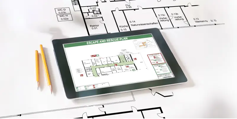 Tablet-Computer auf einem Bauplan mit Flucht- und Rettungsplan