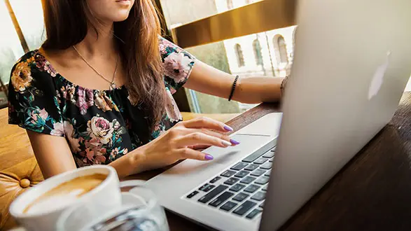 Lady at computer with coffee