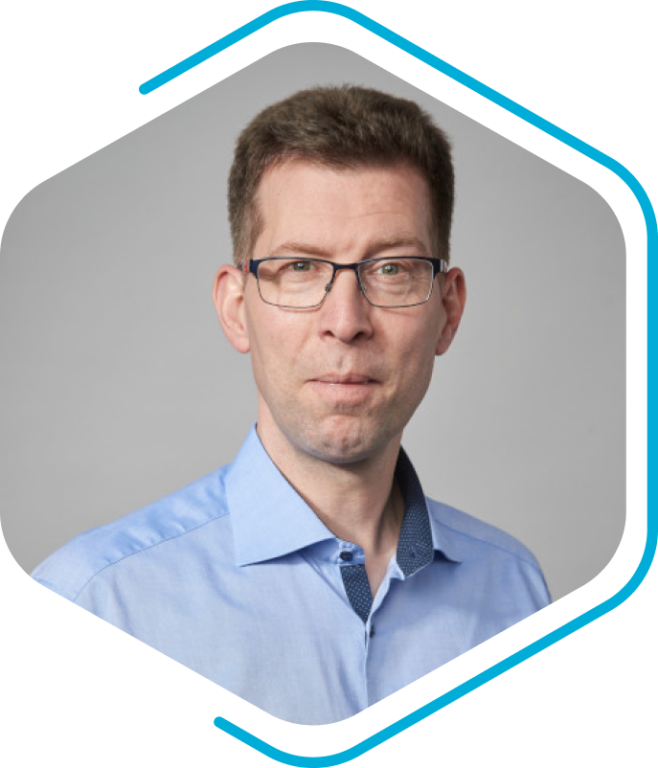 A man in glasses, donning a blue shirt, stands confidently against a plain background framed by a geometric border, reminiscent of the sleek designs of Becker Marine Systeme.