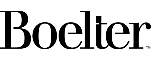 A man in a suit and tie stands holding a clipboard, with one hand raised and index finger pointing upward.