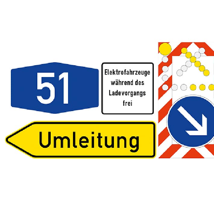 A collection of German road signs in metal construction, featuring a blue 51 sign, a yellow Umleitung detour sign, and signs for electric vehicle charging and rightward direction.